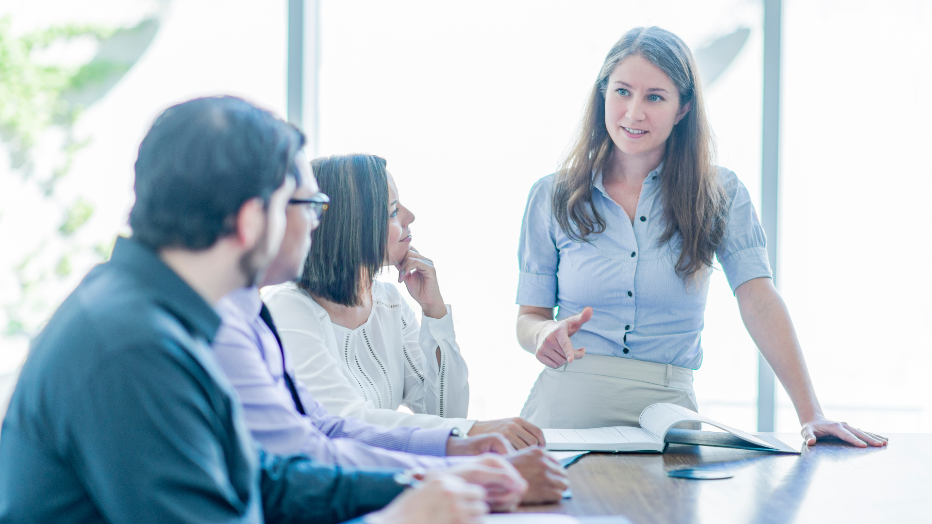 A confident woman addresses her colleagues during a board meeting.